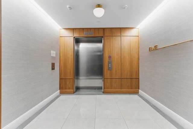 191 Washington St Unit 524, Boston, MA 02135 - corridor with elevator, baseboards, and light tile patterned floors