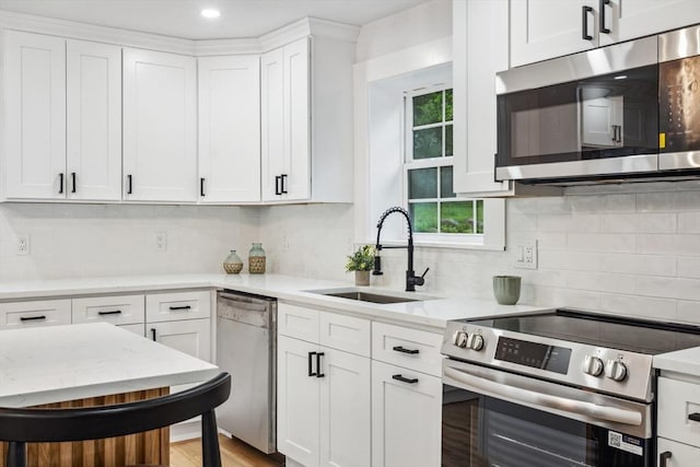 22 Longhill Rd, Ashland, MA 01721 - kitchen featuring stainless steel appliances, a sink, white cabinets, tasteful backsplash, and light stone countertops