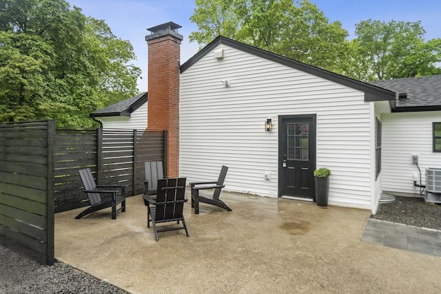 22 Longhill Rd, Ashland, MA 01721 - rear view of property with a shingled roof, a chimney, a patio, and central AC unit