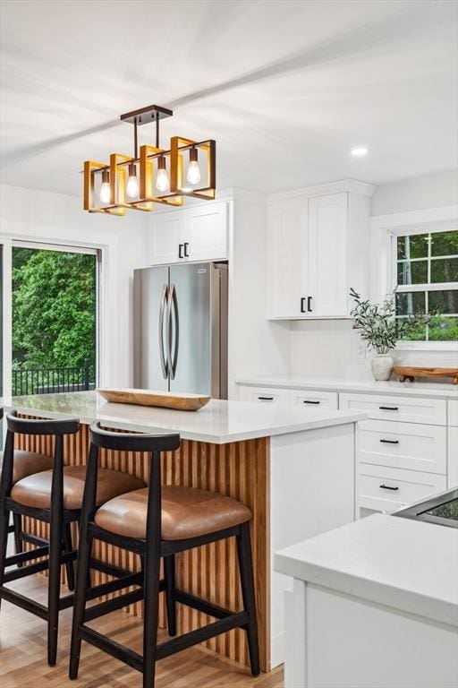 22 Longhill Rd, Ashland, MA 01721 - kitchen featuring freestanding refrigerator, a chandelier, light countertops, a kitchen breakfast bar, and white cabinetry
