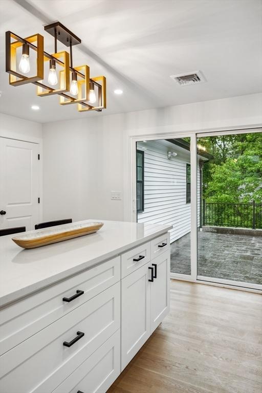 22 Longhill Rd, Ashland, MA 01721 - kitchen featuring a chandelier, white cabinetry, light wood-style floors, decorative light fixtures, and light countertops