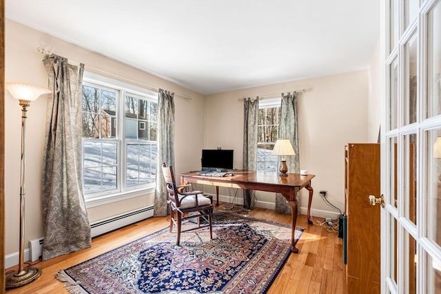 office space featuring baseboards, baseboard heating, and wood finished floors