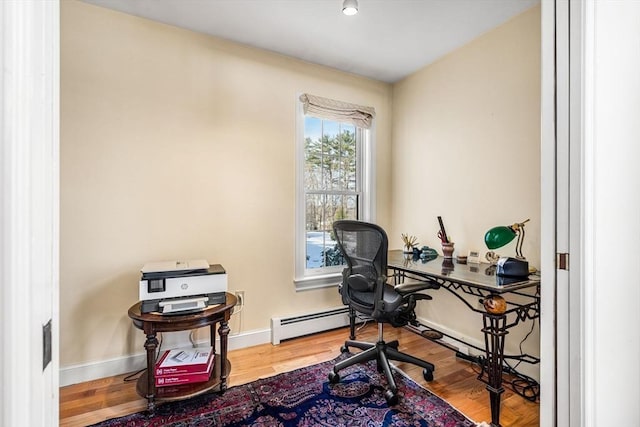 office with a baseboard heating unit, wood finished floors, and baseboards