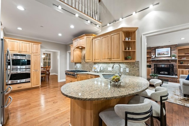 32 Rideout Rd, Hollis, NH 03049 - kitchen featuring appliances with stainless steel finishes, a peninsula, a kitchen bar, crown molding, and light stone countertops