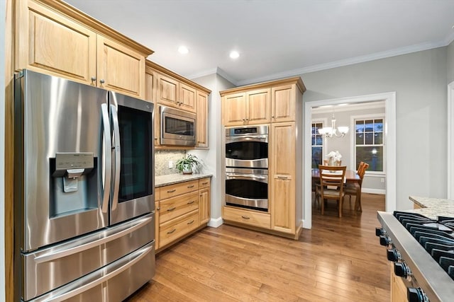 32 Rideout Rd, Hollis, NH 03049 - kitchen with stainless steel appliances, light brown cabinetry, ornamental molding, a chandelier, and light stone counters