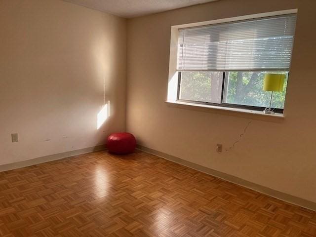 unfurnished room with light parquet flooring and a textured ceiling