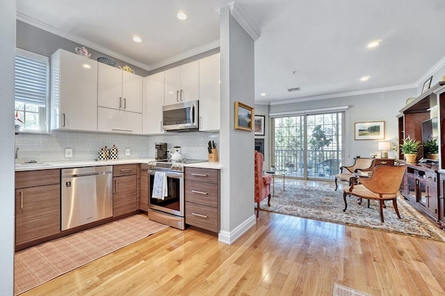kitchen featuring plenty of natural light, light countertops, light wood-style flooring, and stainless steel appliances