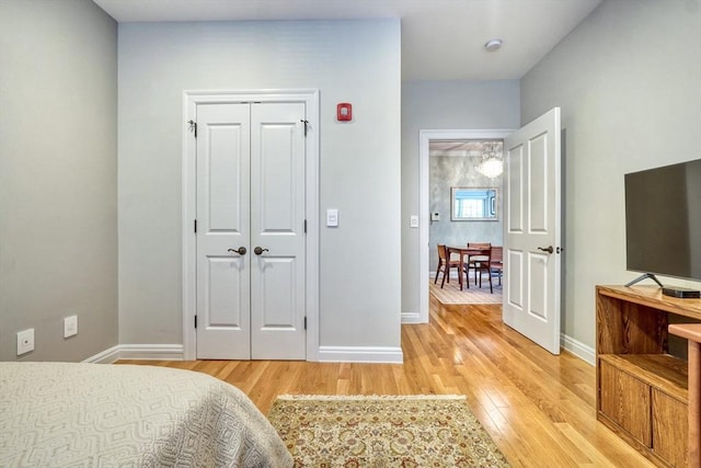 bedroom featuring a closet, baseboards, and light wood-type flooring