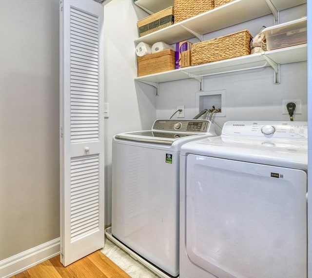 laundry room with baseboards, laundry area, light wood-style flooring, and washing machine and dryer