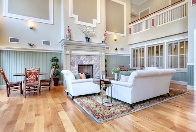 living room with a high ceiling, visible vents, and wood finished floors