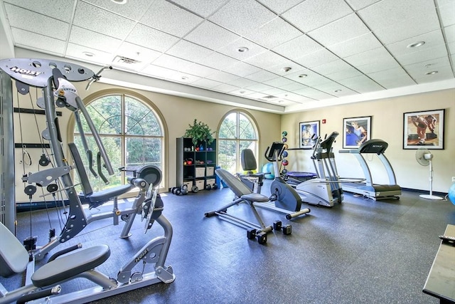 workout area featuring baseboards, visible vents, and a paneled ceiling