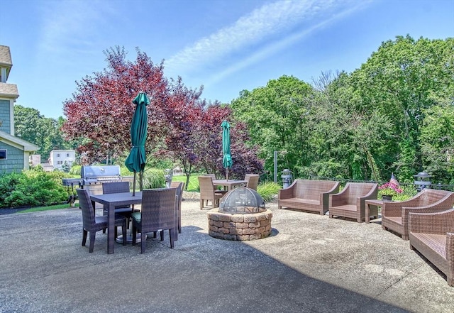view of patio with a fire pit, outdoor dining area, and a grill