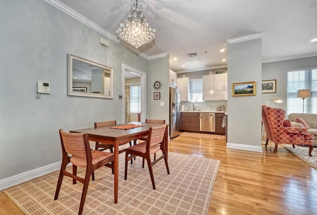 dining space with a chandelier, a wealth of natural light, and light wood-style flooring