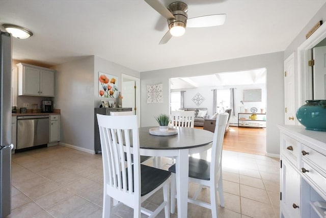 dining room with light tile patterned flooring, a ceiling fan, and baseboards