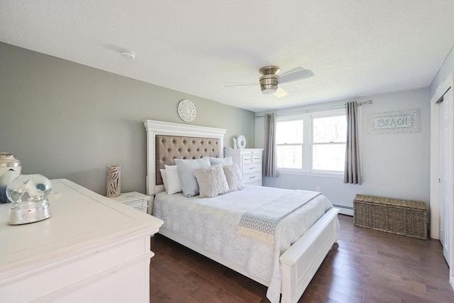 bedroom featuring a baseboard radiator, dark wood finished floors, and ceiling fan