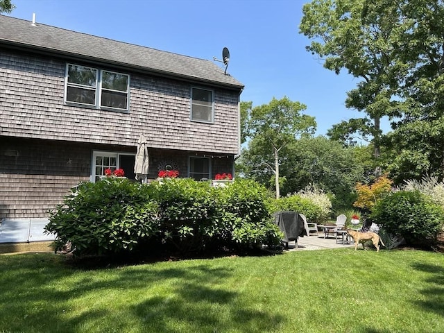 back of property featuring a lawn and a patio