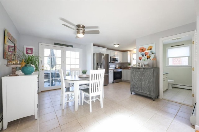 dining space featuring a baseboard heating unit, ceiling fan, and light tile patterned flooring