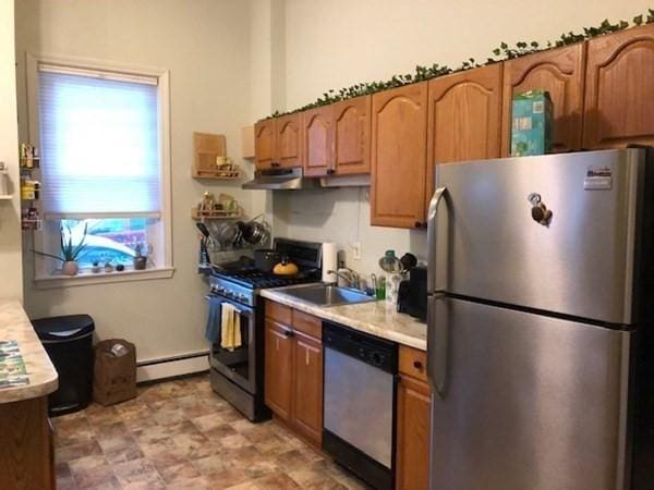 kitchen with stainless steel appliances, a baseboard radiator, light countertops, brown cabinetry, and a sink