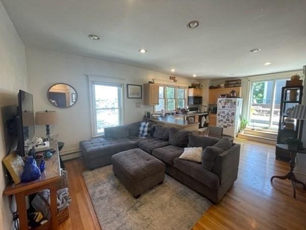 living area featuring wood finished floors, recessed lighting, and a baseboard heating unit