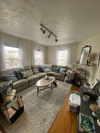 living area featuring rail lighting and a textured ceiling