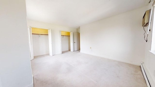 164 Galen St Unit 65, Watertown, MA 02472 - unfurnished bedroom featuring two closets, a baseboard heating unit, and light colored carpet
