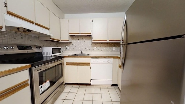 164 Galen St Unit 65, Watertown, MA 02472 - kitchen featuring stainless steel appliances, under cabinet range hood, a sink, light countertops, and backsplash