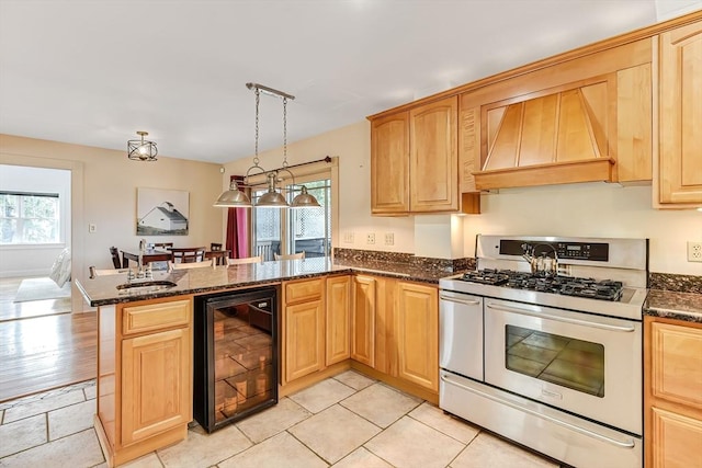 kitchen featuring range with two ovens, wine cooler, a peninsula, and a wealth of natural light