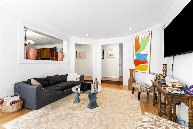 living room featuring an inviting chandelier and light hardwood / wood-style floors