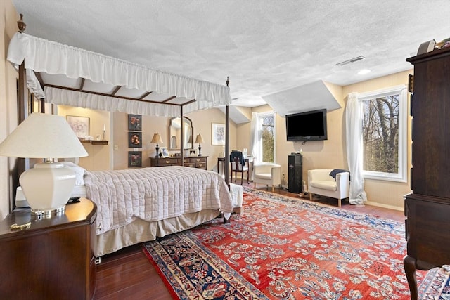 bedroom with a textured ceiling and wood-type flooring