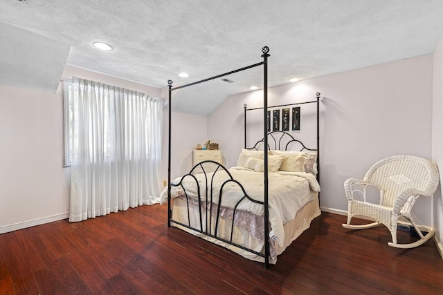 bedroom with a textured ceiling, lofted ceiling, and wood-type flooring