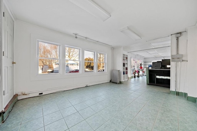 unfurnished living room featuring radiator and tile patterned flooring