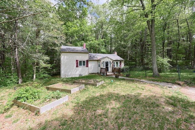 47 Leno Rd, Holland, MA 01521 - view of front of home featuring a garden, a front yard, a chimney, and a wooded view