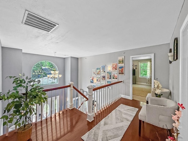 15 Stone Fence Dr, Derry, NH 03038 - hallway featuring wood finished floors, an upstairs landing, and a chandelier