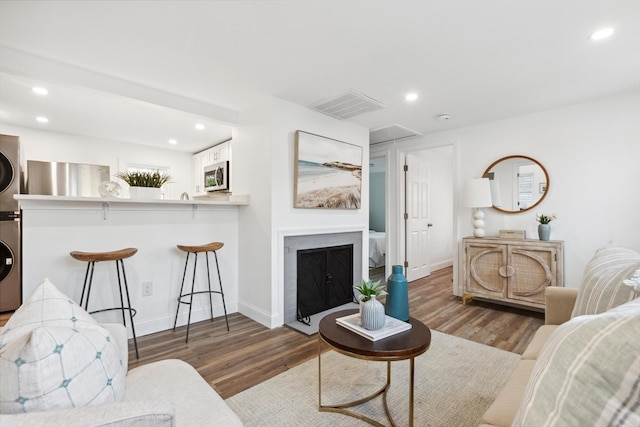 living room featuring hardwood / wood-style floors and stacked washer and clothes dryer