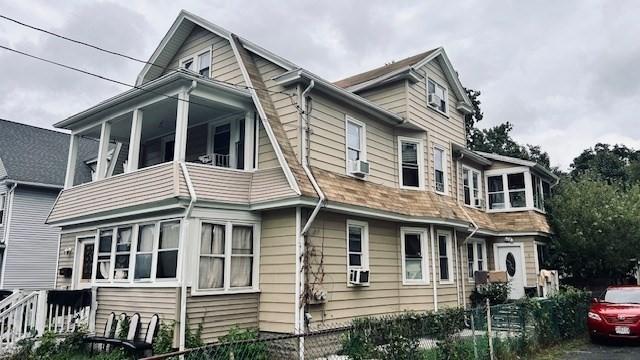 view of side of property featuring a sunroom and cooling unit