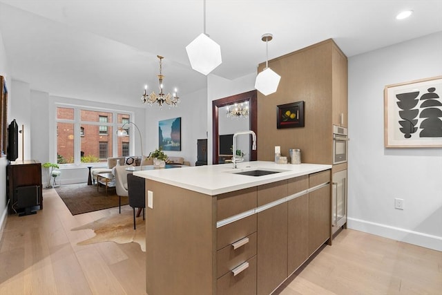 100 Lovejoy Wharf Unit 5N, Boston, MA 02114 - kitchen with modern cabinets, an inviting chandelier, a sink, light countertops, and light wood-type flooring