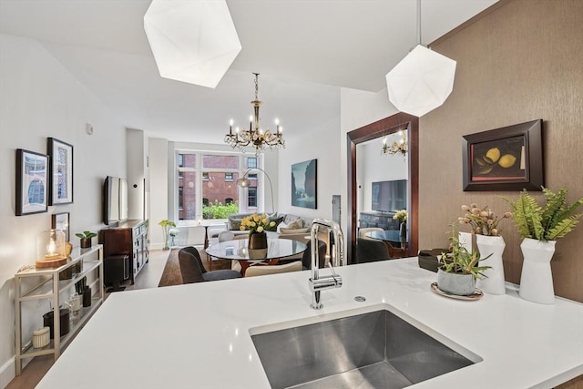 100 Lovejoy Wharf Unit 5N, Boston, MA 02114 - kitchen with a sink, open floor plan, light countertops, hanging light fixtures, and a notable chandelier