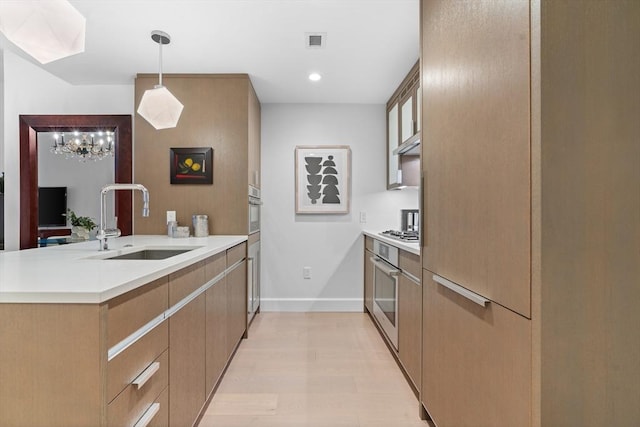 100 Lovejoy Wharf Unit 5N, Boston, MA 02114 - kitchen with a sink, a peninsula, decorative light fixtures, visible vents, and baseboards