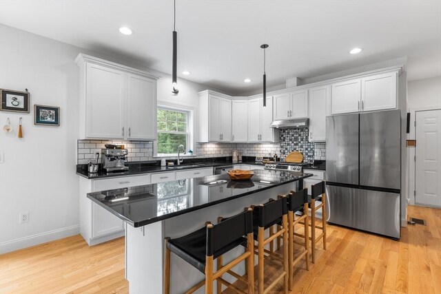 244 Prospect St, Easton, MA 02375 - kitchen featuring freestanding refrigerator, under cabinet range hood, dark countertops, a breakfast bar area, and recessed lighting