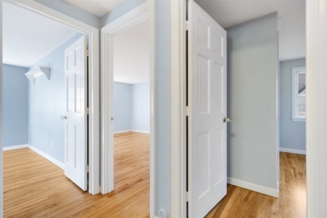 corridor with light hardwood / wood-style floors