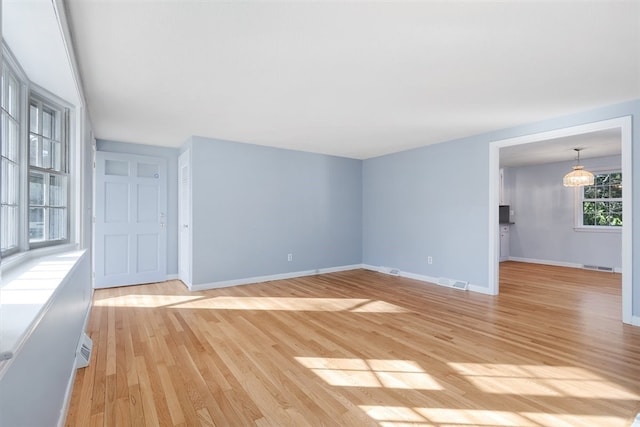 interior space featuring light wood-type flooring and an inviting chandelier