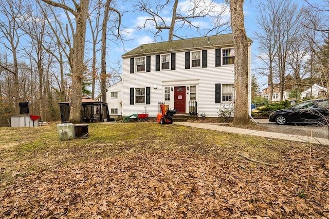 view of front facade with a front yard and a storage shed