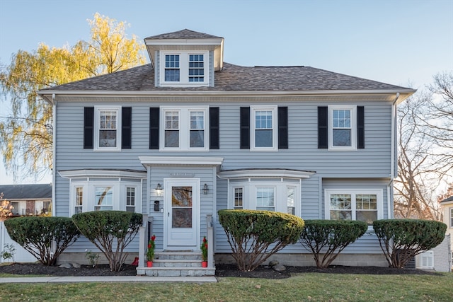 colonial-style house with a front lawn