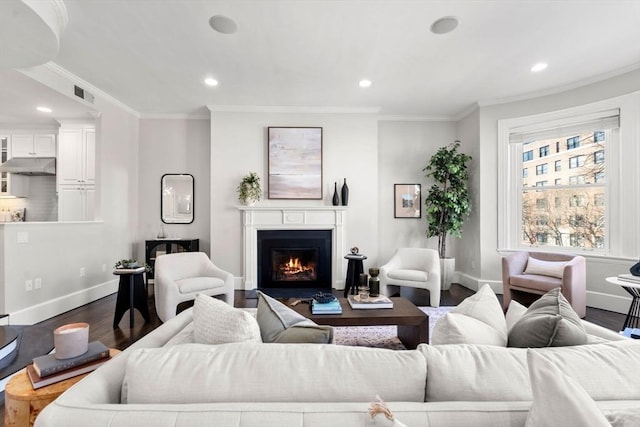 living area with baseboards, a warm lit fireplace, dark wood finished floors, and crown molding