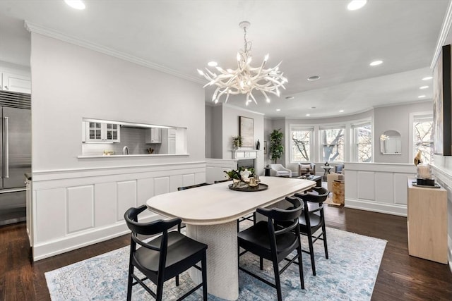 dining space featuring a wainscoted wall, recessed lighting, crown molding, and dark wood-type flooring