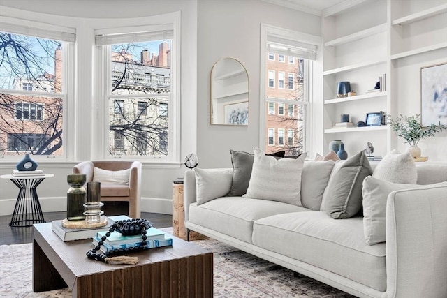 living room featuring built in features, wood finished floors, and a wealth of natural light