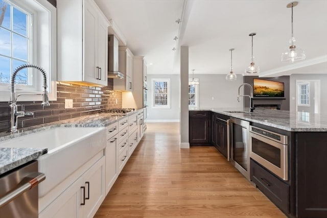 kitchen featuring appliances with stainless steel finishes, white cabinetry, a sink, and tasteful backsplash