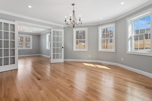 unfurnished dining area with light wood-style floors, a healthy amount of sunlight, a notable chandelier, and baseboards