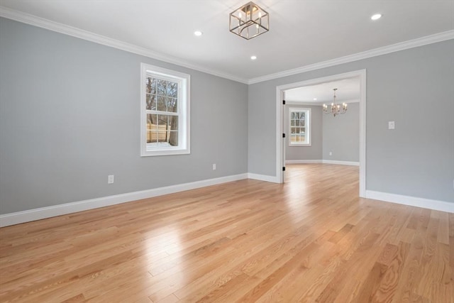 empty room with baseboards, ornamental molding, light wood-type flooring, and an inviting chandelier