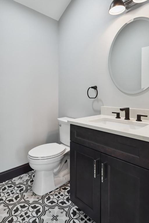 bathroom featuring tile patterned flooring, baseboards, vanity, and toilet